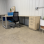 Modern office setup with a L-shaped desk, chair, and cabinets.